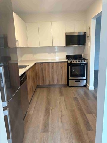 Dartmouth apartment for rent - A kitchen with a black stove top oven and wooden floors.