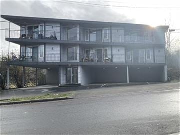 Seattle apartment for rent - A large, two-story building with balconies and multiple windows.