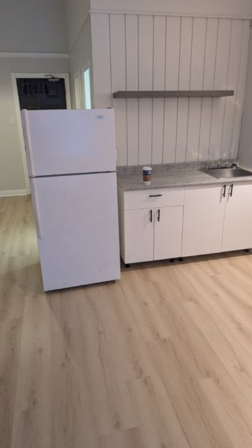 North Bay apartment for rent - A white refrigerator is in a kitchen with wooden floors.