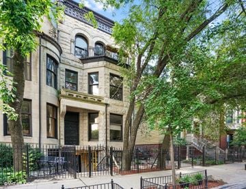 Chicago apartment for rent - A large, old building with a black iron fence in front.