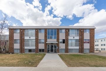 Edmonton apartment for rent - A large building with a grassy area in front.