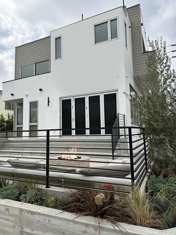 Santa Monica apartment for rent - A modern white house with black railings and a black dog on the steps.