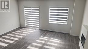 Cambridge townhouse for rent - A room with a wooden floor and two windows with blinds.