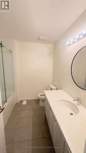 Cambridge townhouse for rent - A white sink in a bathroom with a round mirror and a toilet in the corner.