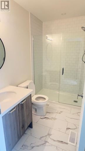 Cambridge townhouse for rent - A white toilet sits in a bathroom with a walk-in shower.