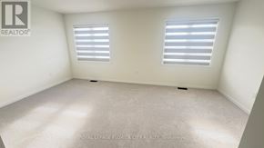 Cambridge townhouse for rent - A white room with two windows and a carpet floor.