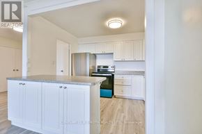 Barrie (Wellington) multi-family for rent - A kitchen with white cabinets and a blue island.