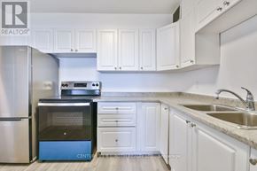 Barrie (Wellington) multi-family for rent - A kitchen with white cabinets and a blue dishwasher.