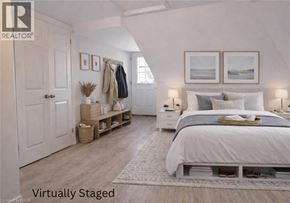 Hamilton house for rent - A bedroom with a bed, nightstands, and a coat rack.