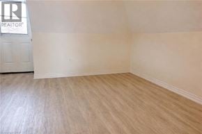 Hamilton house for rent - A room with a wooden floor and a door with a REALTOR sign on it.
