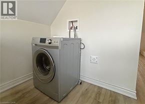 Hamilton house for rent - A washing machine is placed in a room with a white wall and a socket.