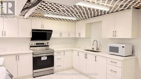 Toronto (Agincourt South-Malvern West) house for rent - A kitchen with white cabinets and a black stove top oven.