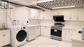 Toronto (Agincourt South-Malvern West) house for rent - A modern kitchen with white appliances and cabinets.