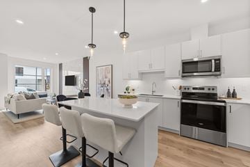 London apartment for rent - A modern kitchen with a white island and stainless steel appliances.