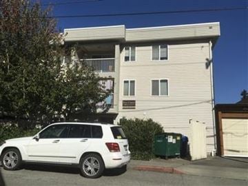 Seattle apartment for rent - A white SUV is parked in front of a two-story apartment building.
