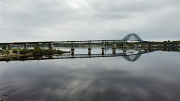 Miramichi apartment for rent - A bridge spans across a body of water under a cloudy sky.