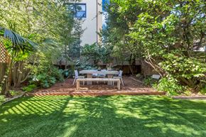 San Francisco apartment for rent - A backyard with a table and chairs surrounded by trees.