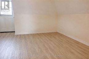 Hamilton (Stinson) house for rent - A room with a wooden floor and a door with a sign that says "REALTOR".