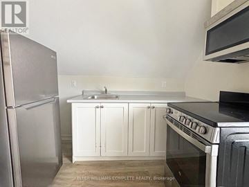 Hamilton (Stinson) house for rent - A kitchen with white cabinets and a stainless steel refrigerator.