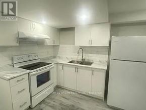 Brampton (Northwest Brampton) house for rent - A white kitchen with a stove, sink, and refrigerator.