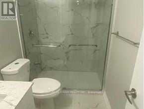 Brampton (Northwest Brampton) house for rent - A white toilet sits next to a walk-in shower with a glass door.