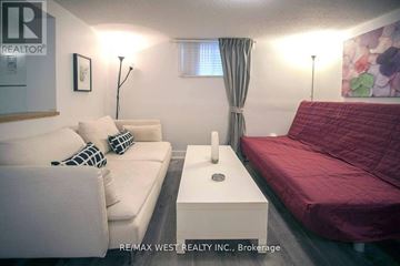 Toronto (Yorkdale-Glen Park) house for rent - A living room with a white couch and a red bed.