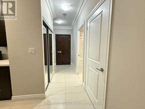 Markham (Commerce Valley) condo for rent - A hallway with white walls and a brown door.