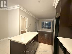 Markham (Commerce Valley) condo for rent - A kitchen with dark wood cabinets and a white countertop.