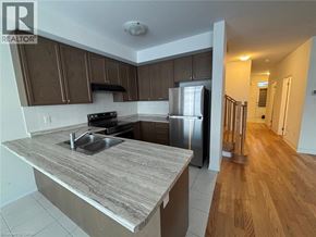 Thorold townhouse for rent - A kitchen with a refrigerator, sink, and stove.