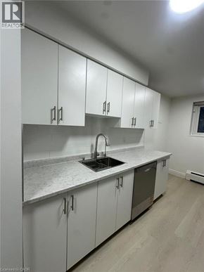 Waterloo apartment for rent - A kitchen with white cabinets and a wooden floor.
