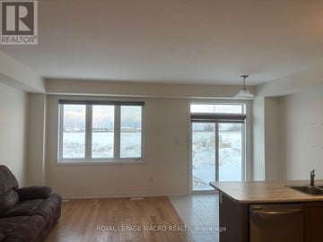 Thorold (Allanburg/Thorold South) townhouse for rent - A living room with a brown leather couch and a wooden countertop.