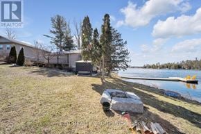 Quinte West (Sidney Ward) house for rent - A house with a large yard and a lake in the background.