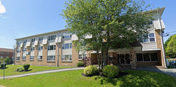 Halifax apartment for rent - A large building with a tree in front of it.