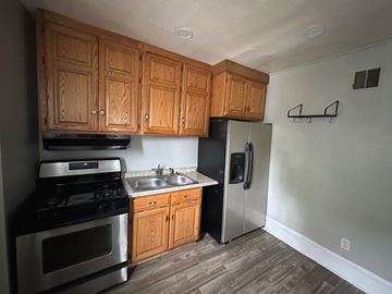 Salt Lake City apartment for rent - A kitchen with wooden cabinets and a stainless steel refrigerator.