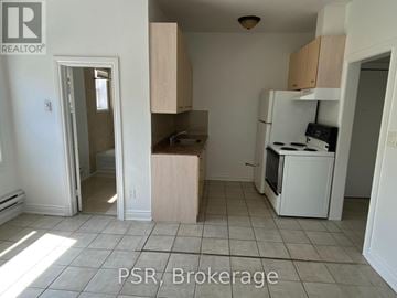 Toronto (New Toronto) house for rent - A kitchen with a refrigerator, sink, and cabinets is for sale.