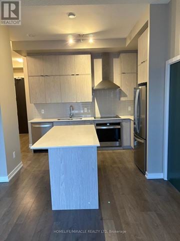 Kitchener condo for rent - A kitchen with a white island in the middle of it.