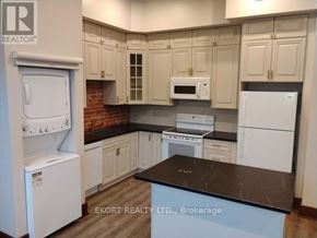 Belleville (Belleville Ward) house for rent - A kitchen with white appliances and a black countertop.