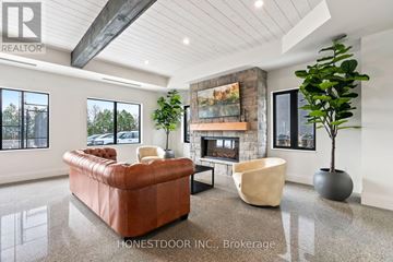 Brockton multi-family for rent - A living room with a brown leather couch, a fireplace, and a large painting on the wall.