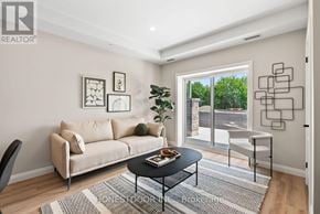 Brockton multi-family for rent - A living room with a beige couch, a coffee table, and a large window.