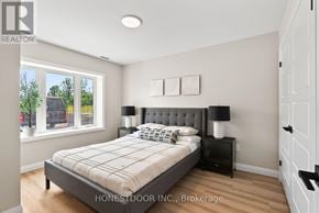 Brockton multi-family for rent - A bedroom with a bed, nightstand, and window.