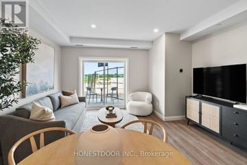 Brockton multi-family for rent - A modern living room with a wooden table and chairs, a grey sofa, and a television.