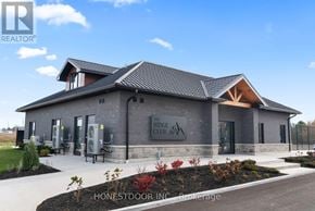 Brockton multi-family for rent - A modern building with a sign that reads "Ridge Club" is surrounded by a landscaped area.