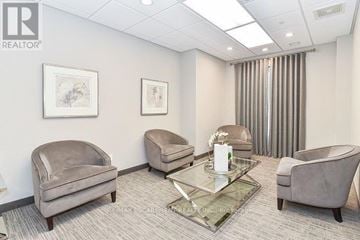 Oakville (Wm Westmount) condo for rent - A living room with a glass coffee table and three grey couches.