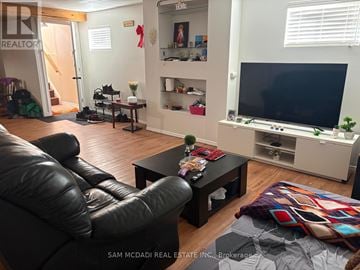 Barrie (Holly) house for rent - A living room with a black leather couch and a flat screen TV.