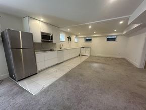 Surrey house for rent - A spacious kitchen with a refrigerator, microwave, and oven.
