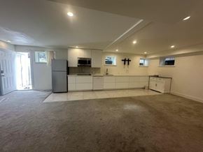 Surrey house for rent - A kitchen with white cabinets and a white refrigerator.