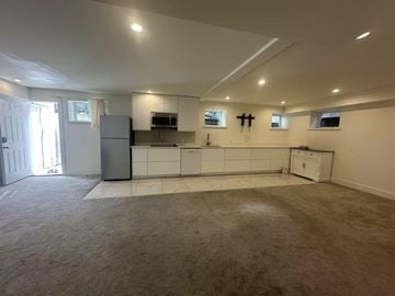 Surrey house for rent - A kitchen with white cabinets and a white refrigerator.