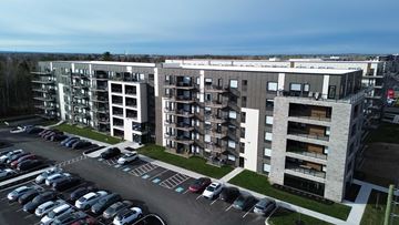 Moncton apartment for rent - A parking lot in front of apartment buildings.