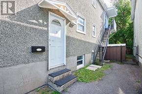 Ottawa triplex for rent - A house with a white door and a small staircase leading to a backyard.
