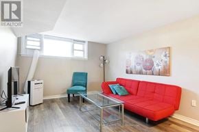 Ottawa triplex for rent - A living room with a red couch, a blue chair, and a glass coffee table.